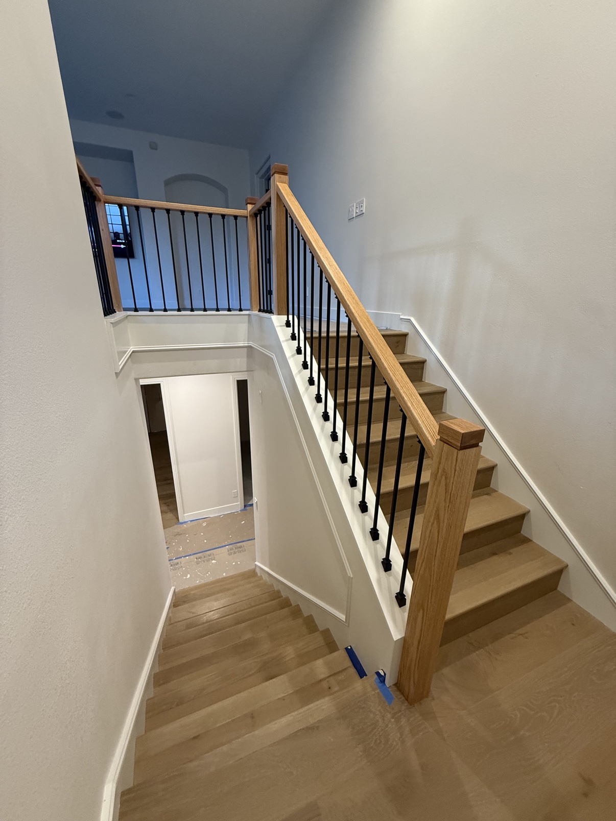 Two-level staircase with wood handrails and light wood treads