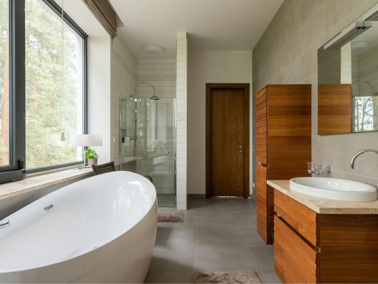 Spacious bathroom with wood cabinetry, soaking tub, and glass shower